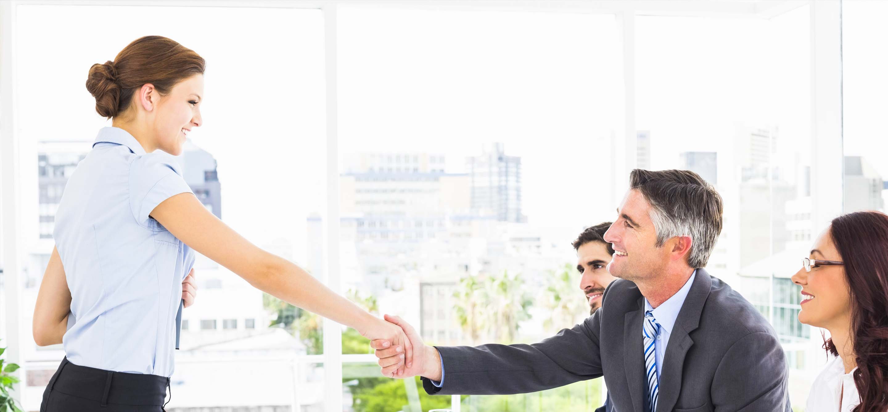 Group of business professionals meeting and shaking hands with an applicant for a job interview.