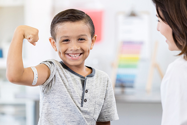 kid smiling with muscle up and bandaid