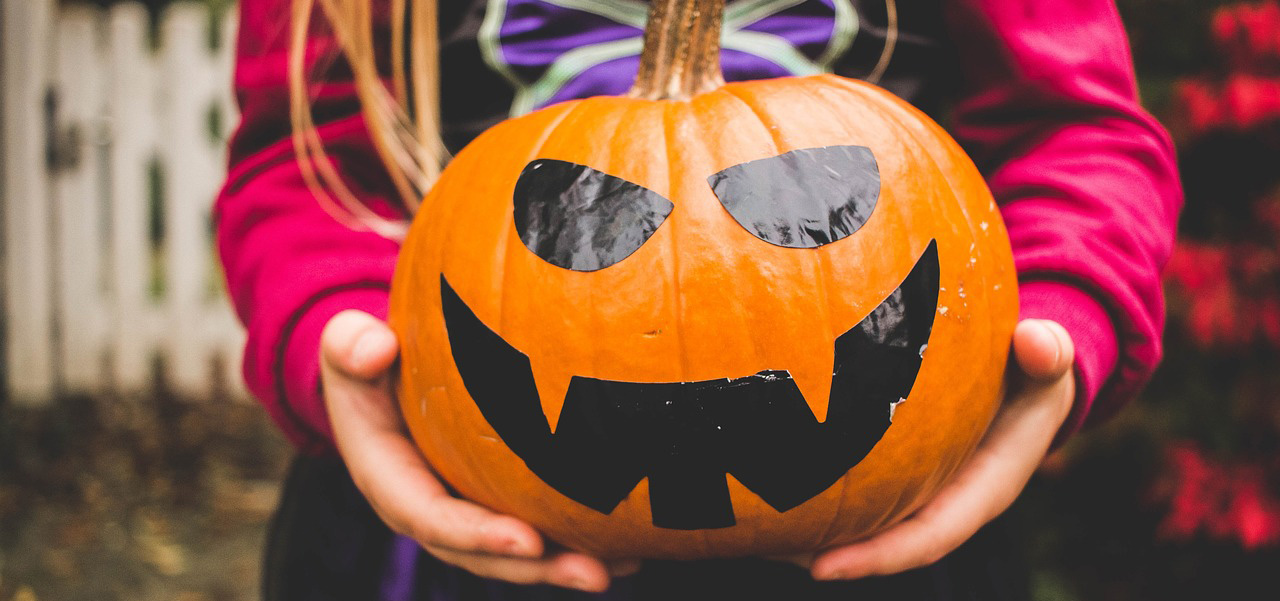 Costumed girl holding pumpkin