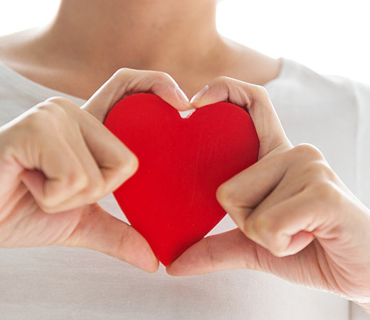 Woman holding stylized heart for American Heart Month