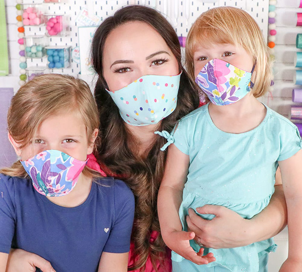 Family with young kids wearing face masks over nose and mouth