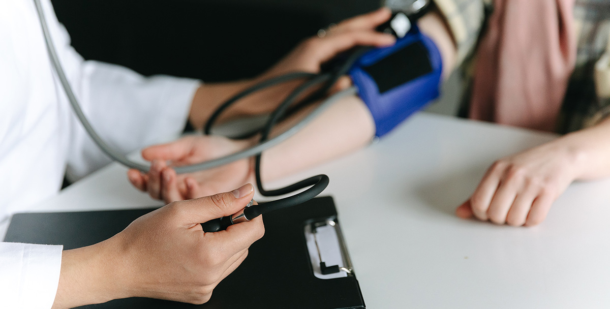 Healthcare professional taking a patient's blood pressure with a blood pressure cuff to check for hypertension | Image by Thirdman on Pexels