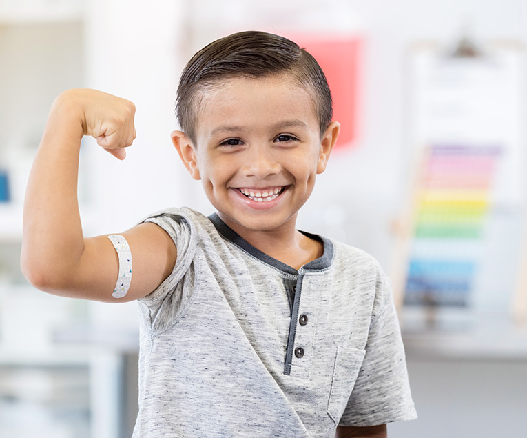 Happy young boy with band-aid at the doctor's office