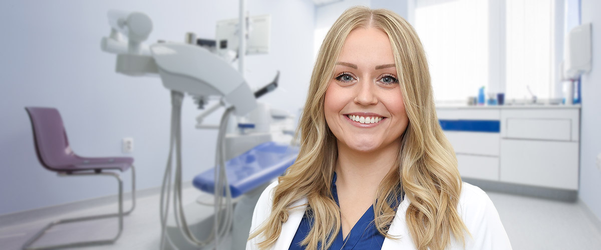 Photo of dentist Dr. Melody DeMatteis standing in a dental office. Dr. DeMatteis provides comprehensive dentistry services to patients of all ages in Blossburg, PA; to make an appointment, call 570-638-3468.