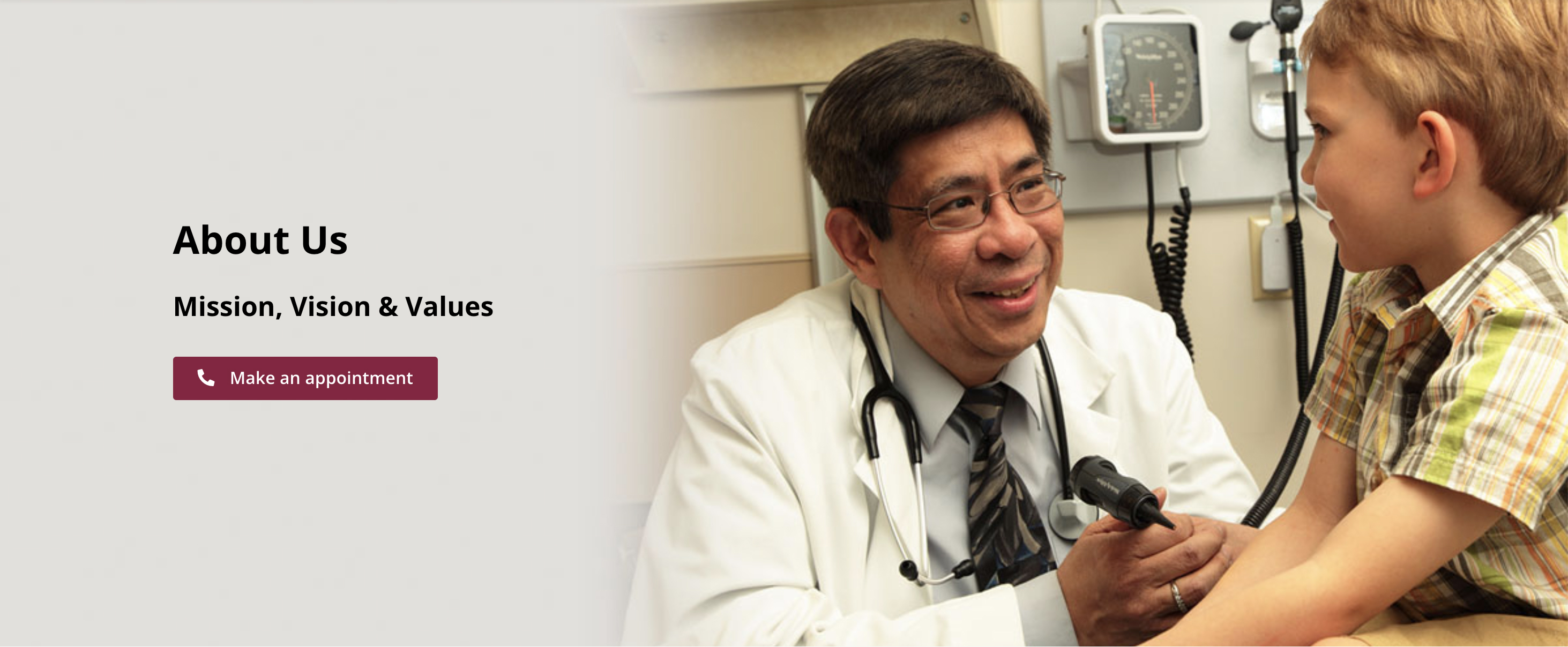 Laurel Health physician Dr. George Dy smiles as he performs a well child checkup on a young patient. Dr. Dy is wearing a stethoscope and a white coat; he is holding an otoscope in his hand, which is used to examine the ear canal.