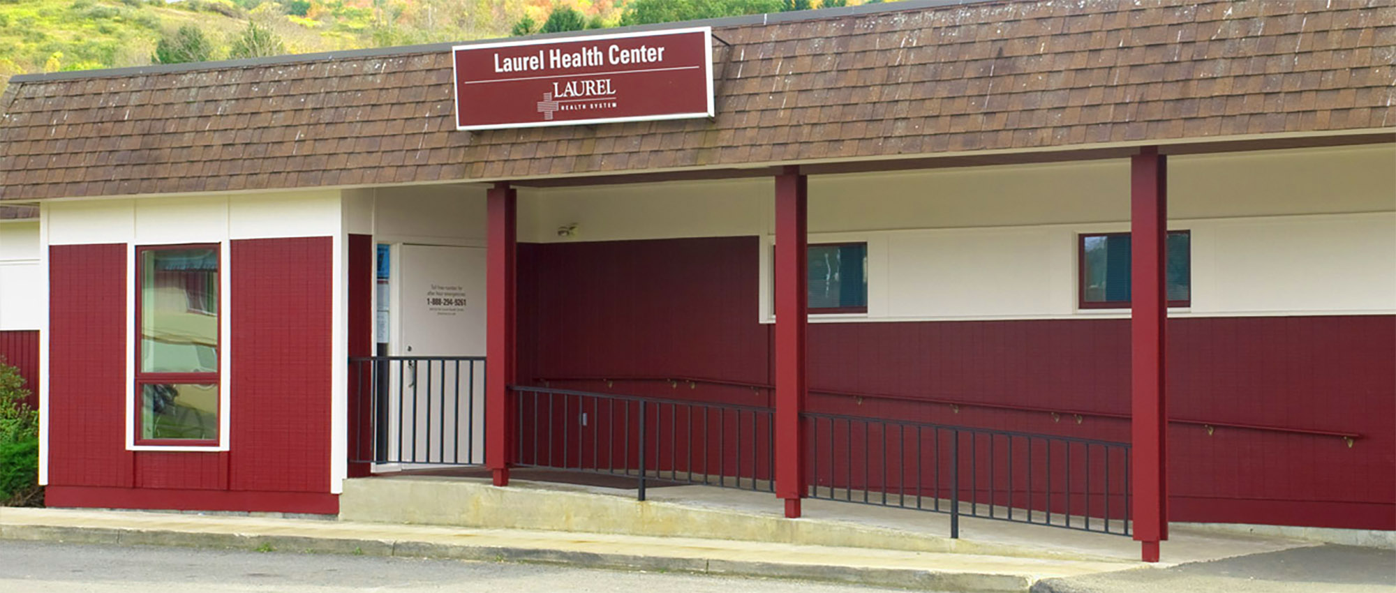 Front of the Elkland Laurel Health Center building. The building is wood sided colored red and white with an access ramp to the entrance.